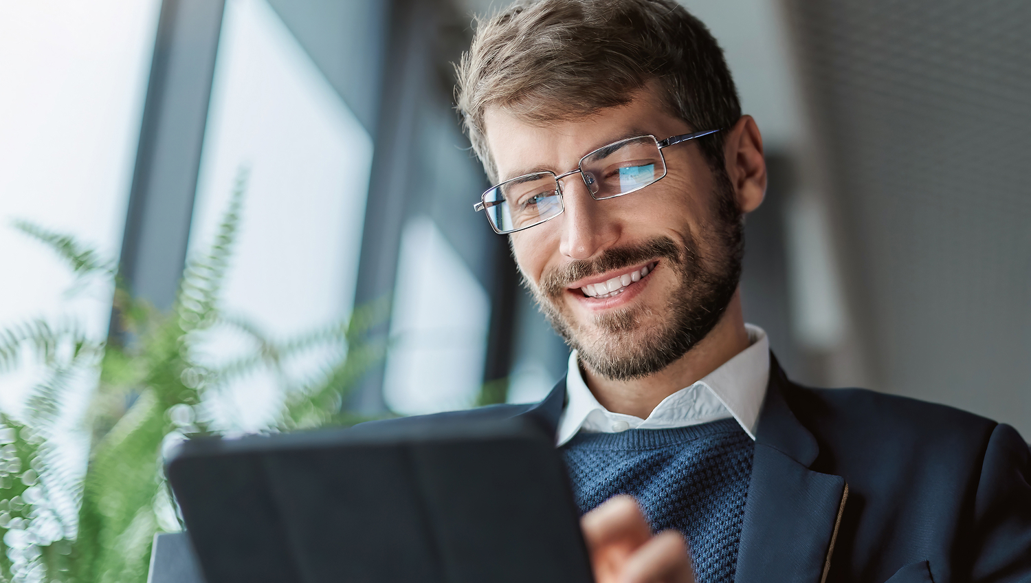 Professional individual interacting with a tablet, smiling